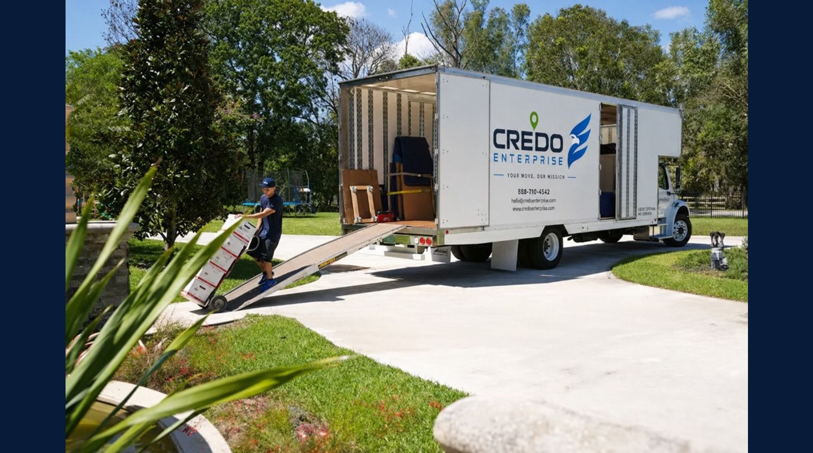Credo Enterprise moving truck at a Florida home with a crew unloading boxes on the driveway