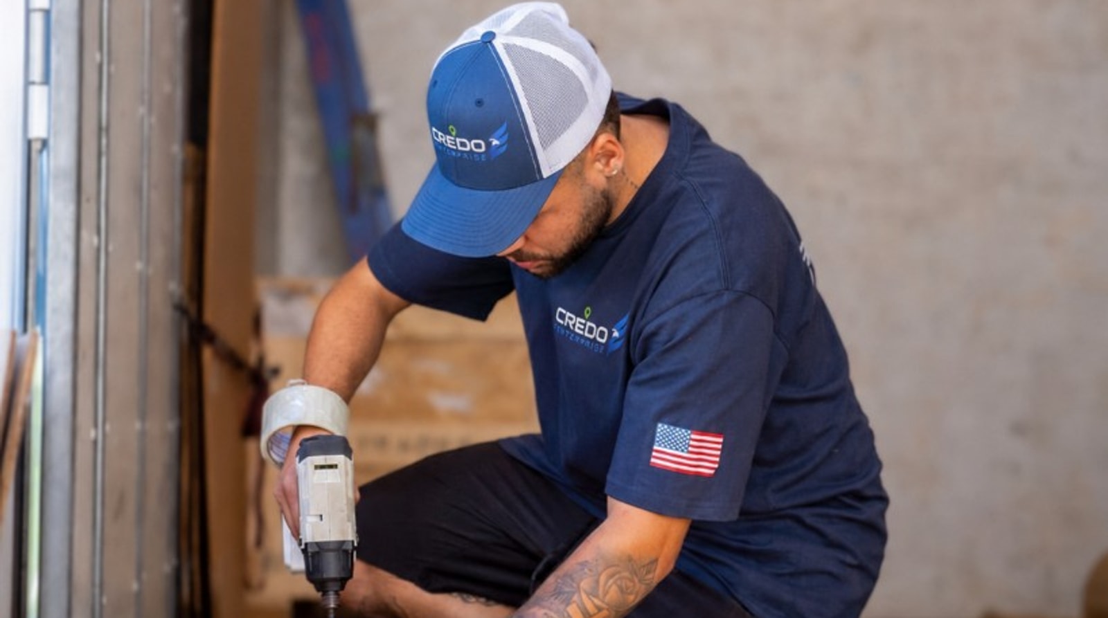 Credo Enterprise mover building a custom wooden crate inside a branded moving truck