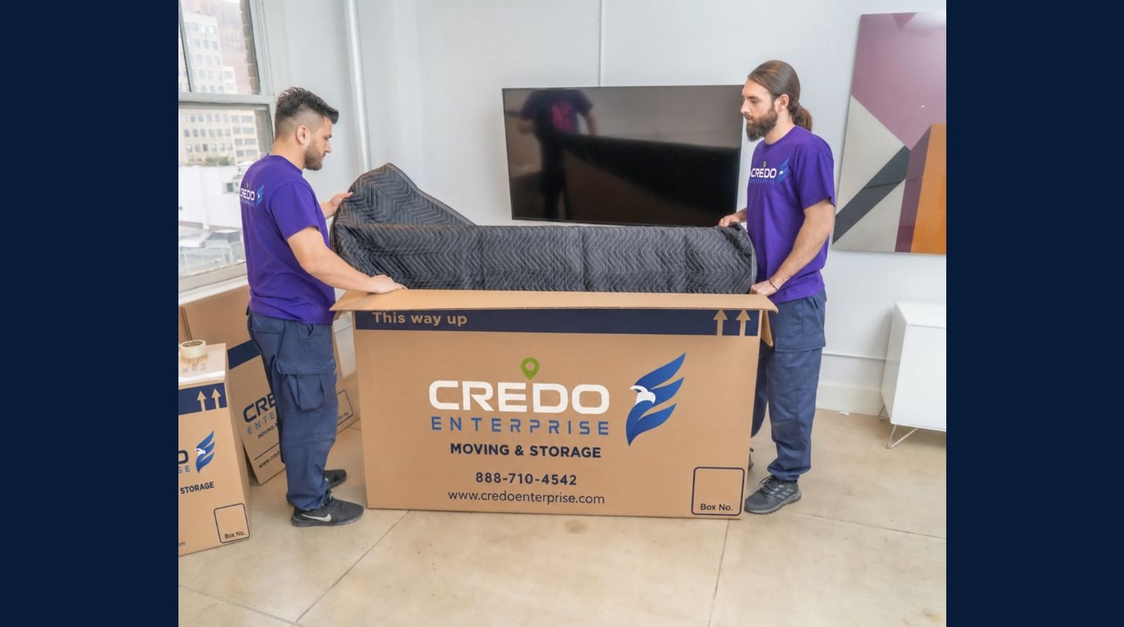 Credo Enterprise movers packing a television in a branded dish-pack box with quilted moving blankets